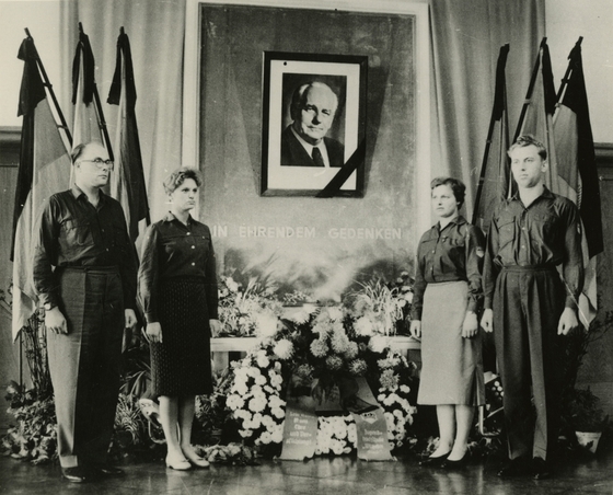 Fahnen, Blumenkränze, Menschen in Uniform vor Portrait von Pieck in FDJ-Schule Bogensee